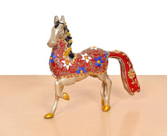 Brass running horse statue, side view, ornate red saddle with blue and gold details