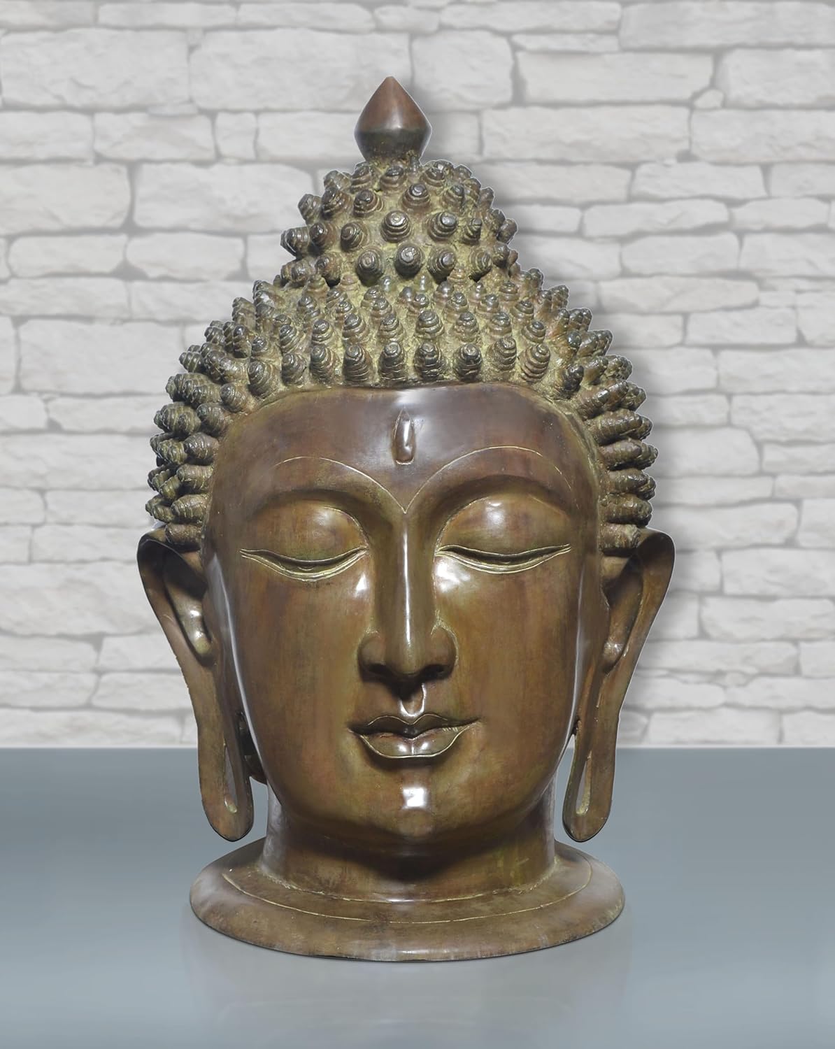 Brass Buddha head statue with serene face, curled hair texture, and elongated earlobes