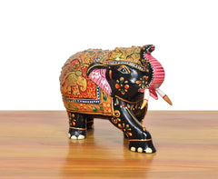 Wooden elephant showpiece, black with red and green patterns, pink-striped ear and curved trunk
