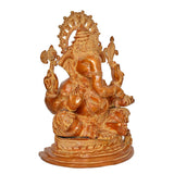 Brass Ganesha statue side view with curved trunk, halo, and four-arm pose