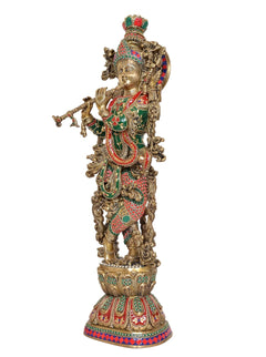 Brass Krishna statue, side profile with teal, red, and gold painted ornaments