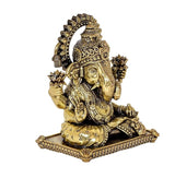 Brass Ganesha idol angled view, trunk raised, fan-like halo, jeweled base