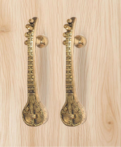 Golden brass sitar-shaped door handle pair with spherical knobs and engraved base