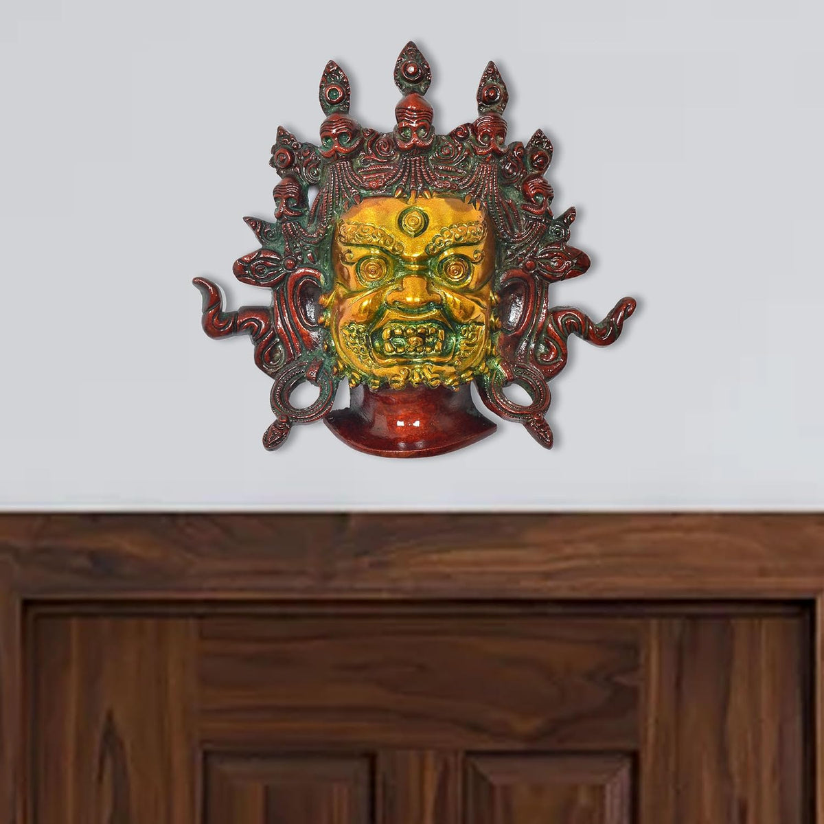 Brass Mahakala wall hanging mask with green, gold and red face details
