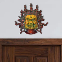 Brass Mahakala wall hanging mask with green, gold and red face details