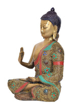 Side view meditating Buddha statue, hands in mudra, brass with blue, green and red accents