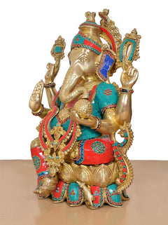 Side view of brass Ganesha statue seated with curved trunk and jeweled headpiece