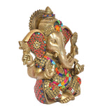Side view of brass Ganesha idol with colorful ear panels and patterned arms