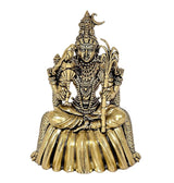 Close-up brass goddess idol, gold tone seated pose with layered jewelry and staff