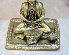 Brass Hanuman idol base and hands close-up, ornate square platform with beaded details