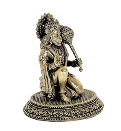Side view of brass Hanuman sitting idol with textured ornaments and round base