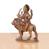 Side view: Durga Maa resin idol on lion with raised weapons and colorful jewelry