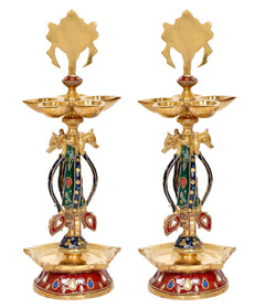 Two brass shankh chakra oil diya lamps, close top view with green and red enamel idols