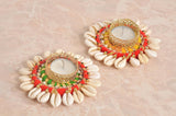 Two Diwali tea light holders with gold lattice rim, cream shell petals, red and green trim