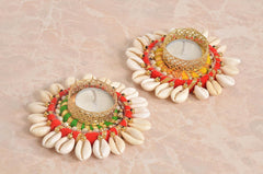 Two Diwali tea light holders with gold lattice rim, cream shell petals, red and green trim