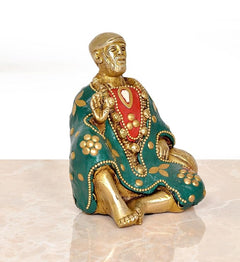 Seated Sai Baba idol in brass, teal robe with gold beads and open-hand gesture