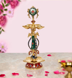 Brass chakra oil lamp diya with painted green-red deity and three bowl tiers on base