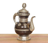 AONA brass teapot with ornate lid cap, curved handles, dark brown belly with embossing