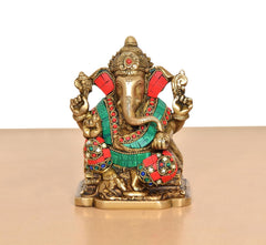 Brass Ganesh murti with colorful jeweled garb and raised hands, close-up