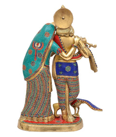 Brass Radha-Krishna idol close-up; Krishna holds flute, Radha teal sari panel