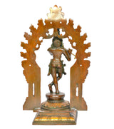 Back view of brass Krishna playing flute idol with decorative arched frame and pedestal