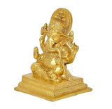 Brass Ganesha idol side view, seated figure with raised hands and engraved pedestal