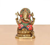 Front view brass Ganesha figurine with jeweled crown and red skirt, seated pose