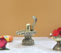 Brass shivling with raised cobra hood, decorative platform and pedestal.