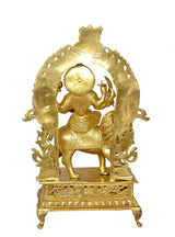 Brass Durga statue idol close-up showing halo arch, lion, and raised hand