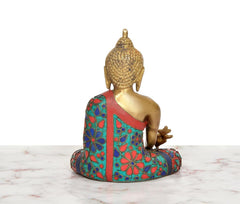 Rear/three-quarter view of brass Buddha statue in multicolor patterned robe