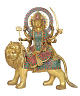 Brass Durga Maa idol on lion, circular halo behind head, detailed jewelry and weapons