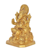 Golden Ganesha deity statue with lifted hand ornaments, seated on round pedestal