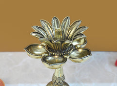Brass lotus oil lamp top with five petals and three leaf-like cups, close-up