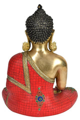 Back view of brass Buddha idol, red mosaic robe with ornate gold trim