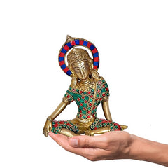 Hand-held view of Brass Indra Dev idol, seated figure with blue-red halo and jeweled robe