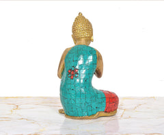 Brass Buddha idol from behind, teal back and blue robe with red patterned bottom