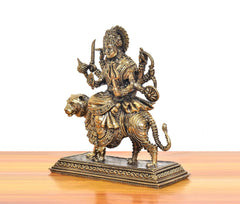 Bronze Durga Maa idol riding tiger, side view with wheel-like charm and raised hand