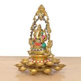 Brass Ganesh diya with 21 oil lamps, angled view of decorative arch and bowl base