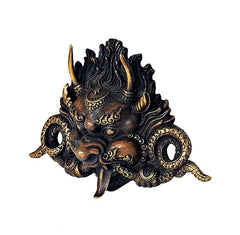Brass cheepu mask wall decor, side-angle view of ornate face with round openings