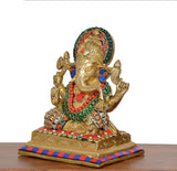 Angled view Ganesha idol with jeweled crown, blue eyes, multicolour ornaments