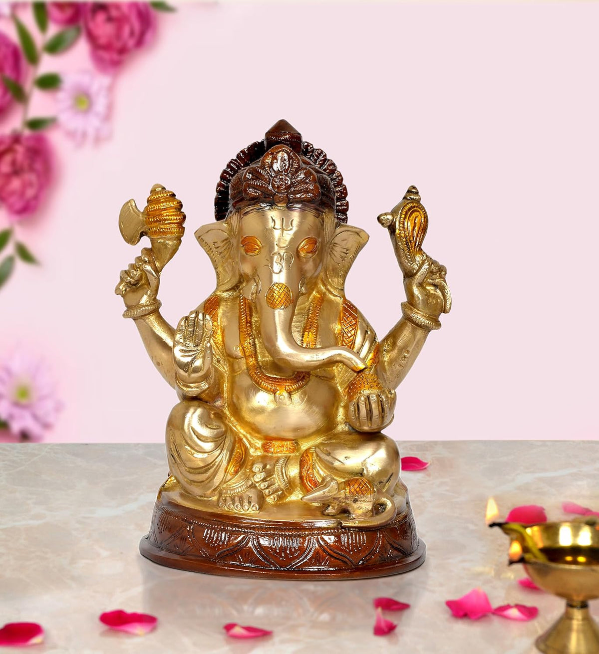 Gold-tone brass Ganesha idol with raised arms, seated on a carved base