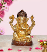Gold-tone brass Ganesha idol with raised arms, seated on a carved base