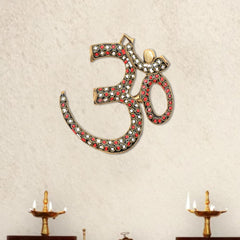 Brass OM wall hanging sculpture with red, white, and black gem-style inlay