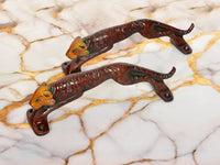 Jaguar-shaped brass door handle pair, front view with orange cat head accents