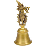 Brass Krishna bell idol, side view, ornate figure holding flute on bell base