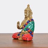 Meditating brass Buddha statue, side view, green sash with blue and red bead accents