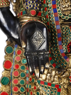 Close-up of black idol hand with engraved design and gold finger accents