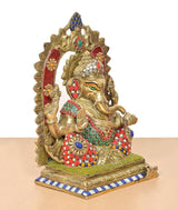 Brass Ganpati Bappa murti, angled view, multicolor ornaments on pedestal