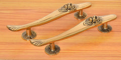 Brass gold door pull handles pair with curved profiles and lion-face end details