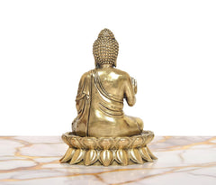 Brass Buddha idol from back view, seated on lotus base, textured crown